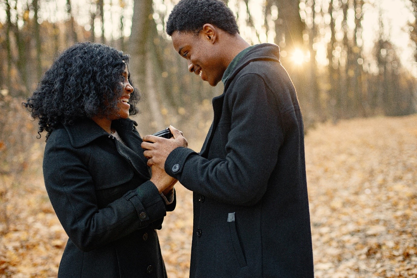 Loving Black couple in park and enjoying autumn sunset